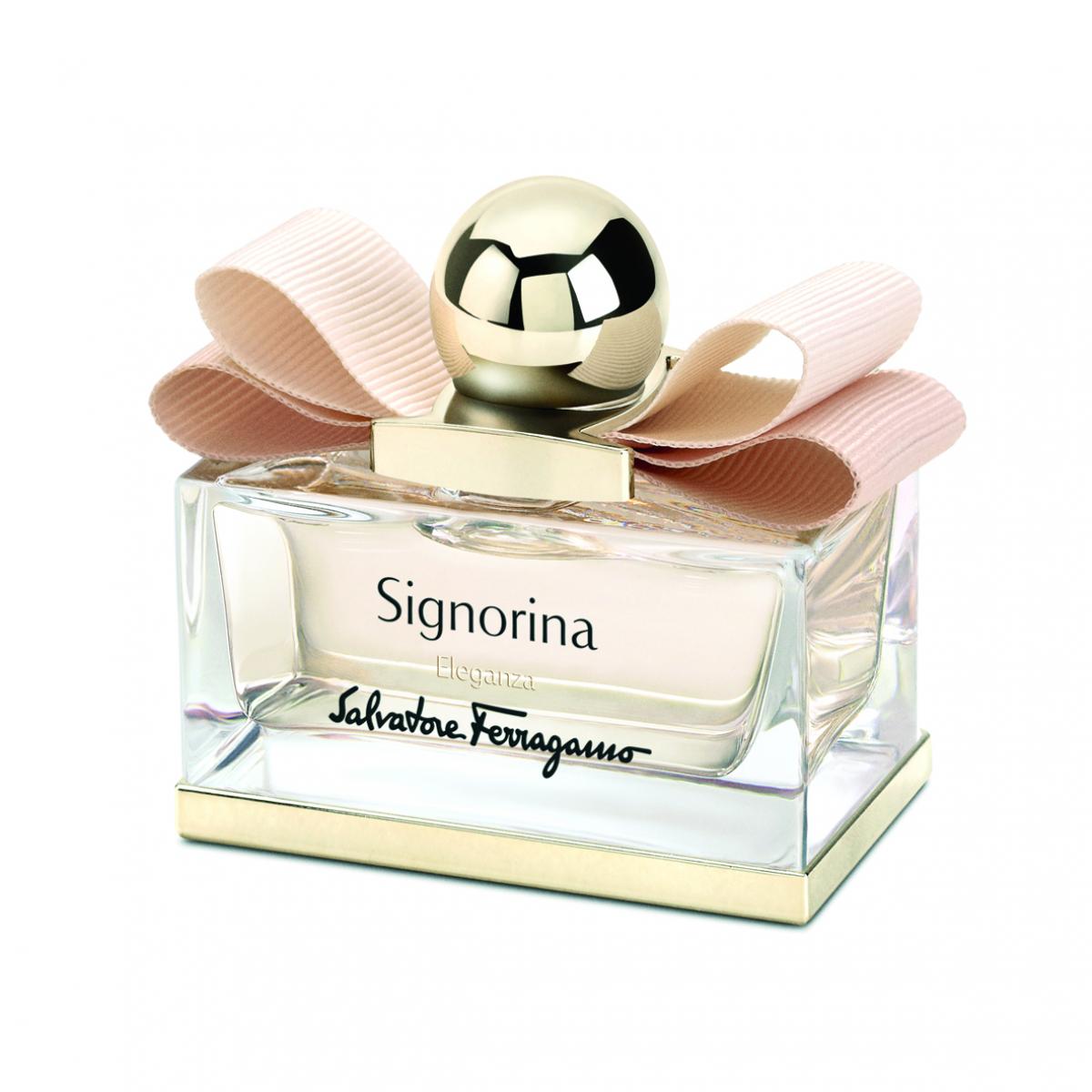 Salvatore Ferragamo Signorina Eau de Parfum bottle with a clear glass rectangular body, a gold cap and a large light pink ribbon bow on a white background.