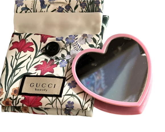 Heart-shaped mirror with floral pouch and Gucci branding
