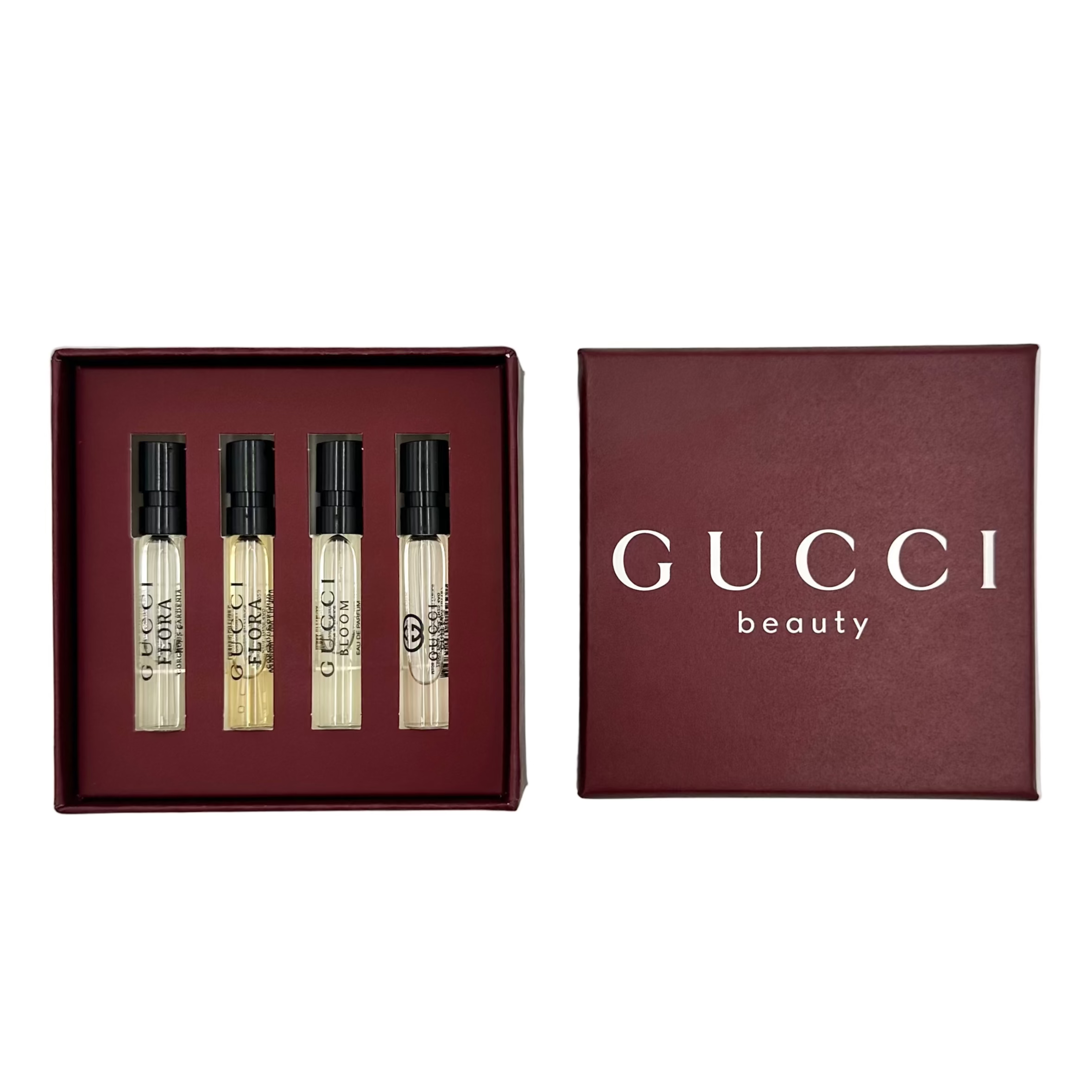 Gucci miniature perfume set with four small bottles and a box on a white background