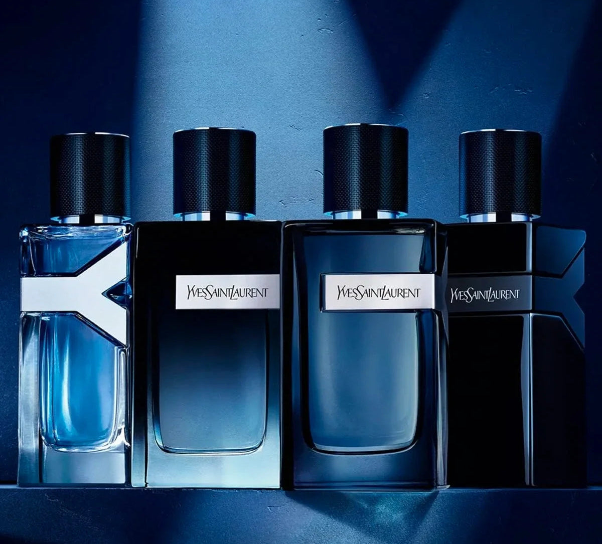 Four Yves Saint Laurent perfume bottles on a blue background